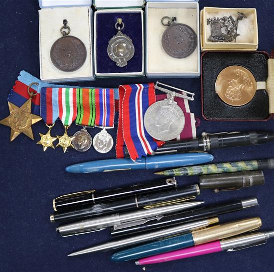 A small box of assorted medallions, pens and medals